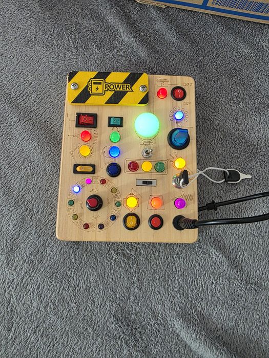 Acesta este o placă senzorială Montessori (sau busy board), o jucărie