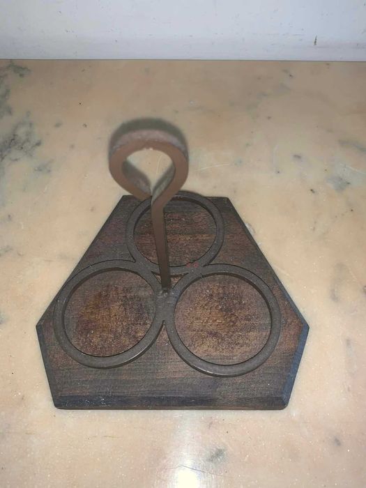 Suport de trei lumanari din fier forjat asezat pe suport de lemn