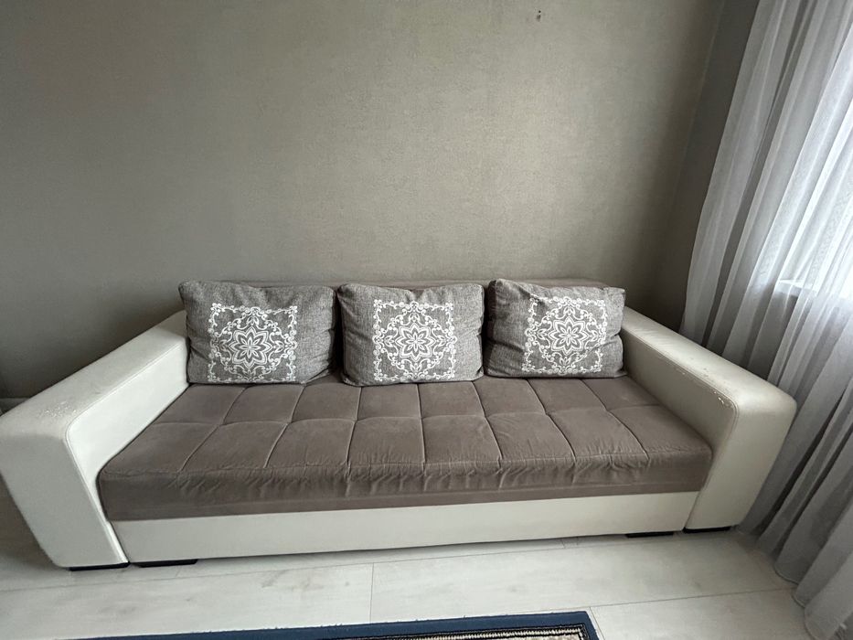 Диван серого цвета с белыми кожаными подлокотниками