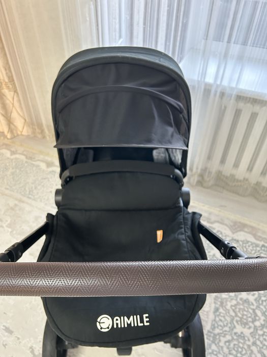 Продаётся современная детская коляска в чёрном цвете.