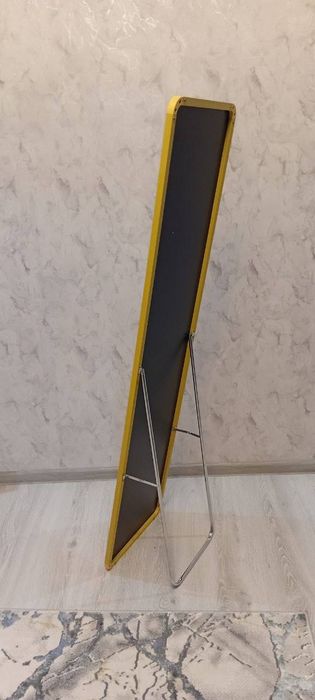 Зеркало в полный рост в тонкой золотистой раме.