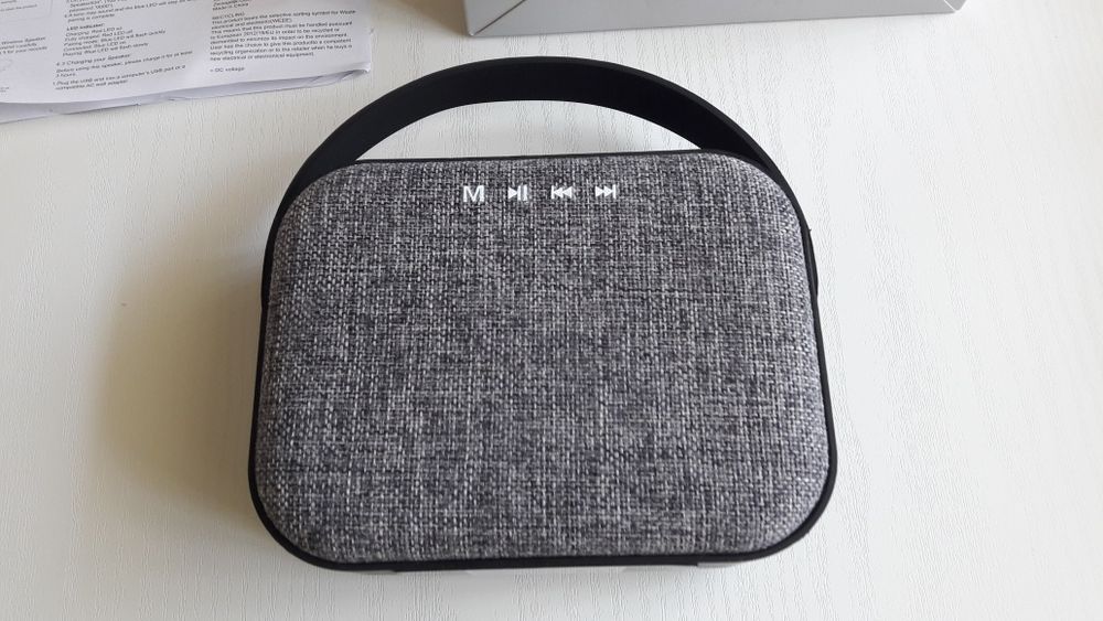 Блутут колонка говорител с текстилна обвивка и гумирана дръжка.