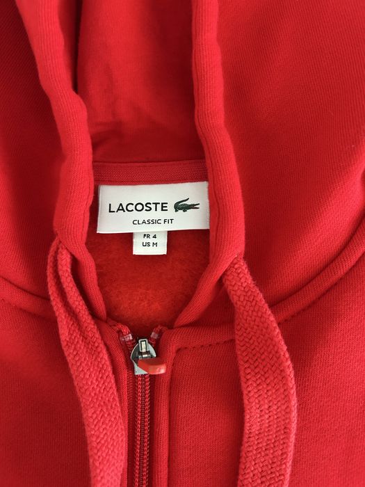 Trening Lacoste format din 2 piese pantaloni negri cu bluza roșie. mărimea M la bluză și mărimea S la pantaloni