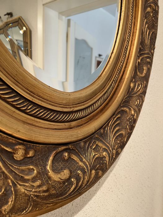 Oglindă ovală decorativă cu ramă aurie sculptată stil baroc (bizotată)