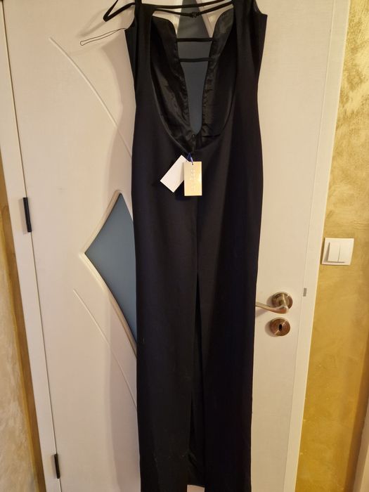 Елегантна черна рокля с изрязан акцент и фини презрамки.