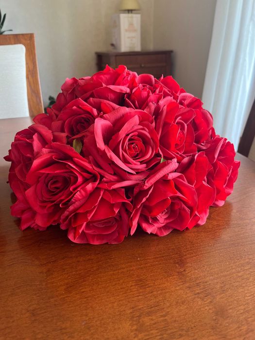 Бяла метална арка с червени рози и друга сватбена украса