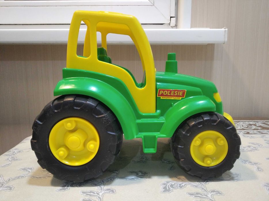 Детская игрушка, трактор и прицеп. Детские игрушки.