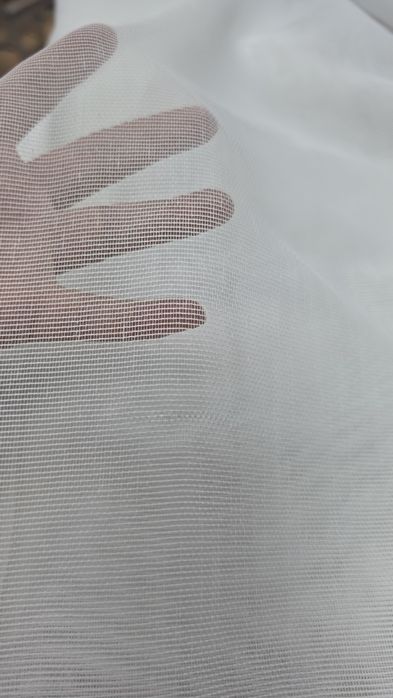 Perdeaua oferă un aspect clasic și rafinat, fiind potrivit pentru interioarele care necesită un plus de luminozitate și o notă discretă de strălucire.