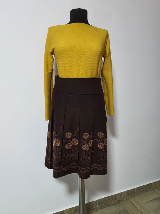 Fusta cu pliuri, material cu tinuta, cu flori cusute manual;