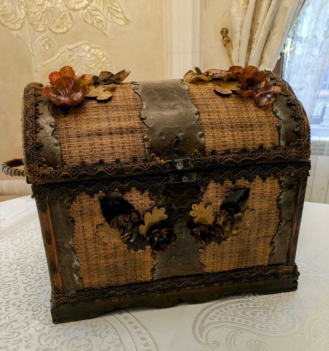 Сандъкът е нов от естествени материали, декориран с метал, кожа, цветя
