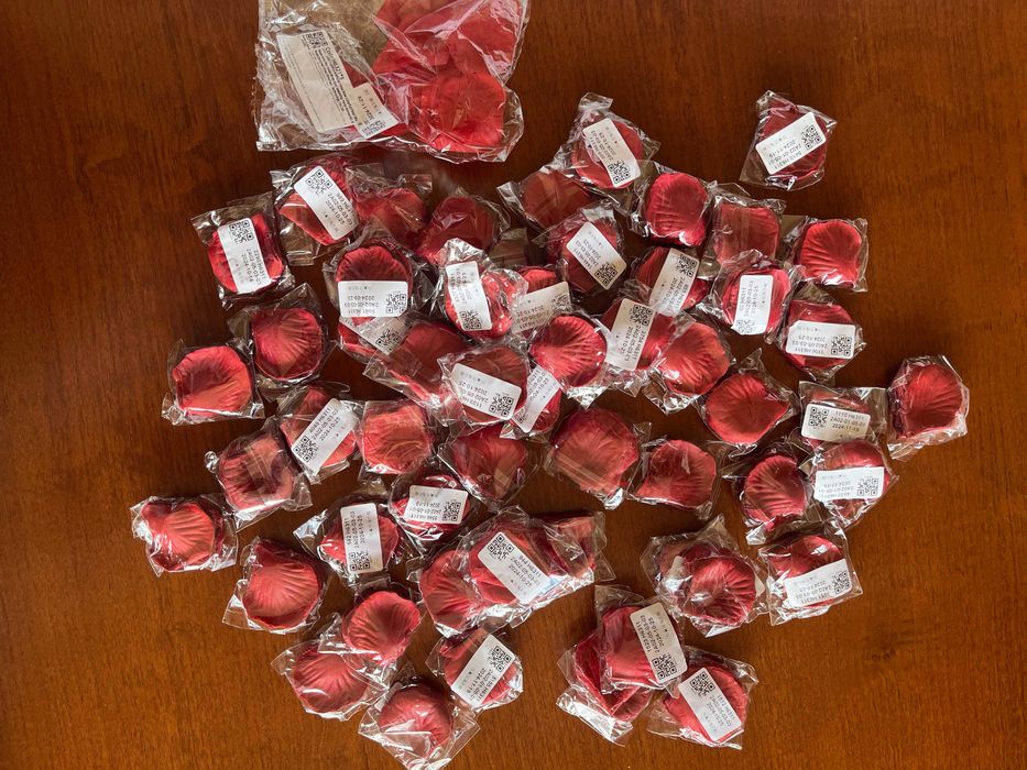 Бяла метална арка с червени рози и друга сватбена украса