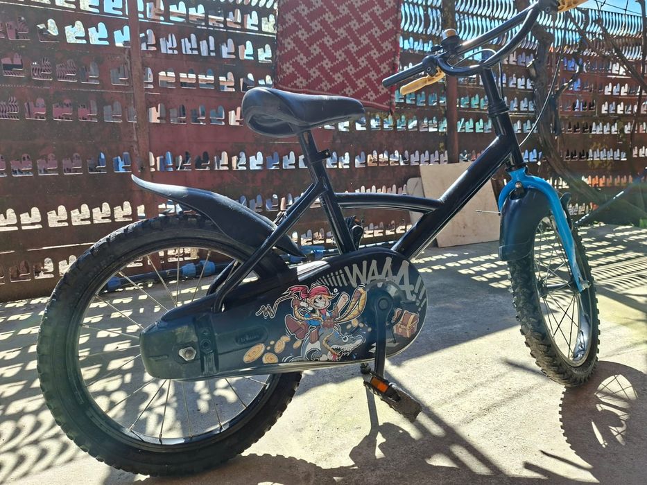 Aceasta este o bicicletă pentru copii B'Twin Pirate de 16 inchi, ideală pentru cei cu vârste cuprinse între 4 și 6 ani.