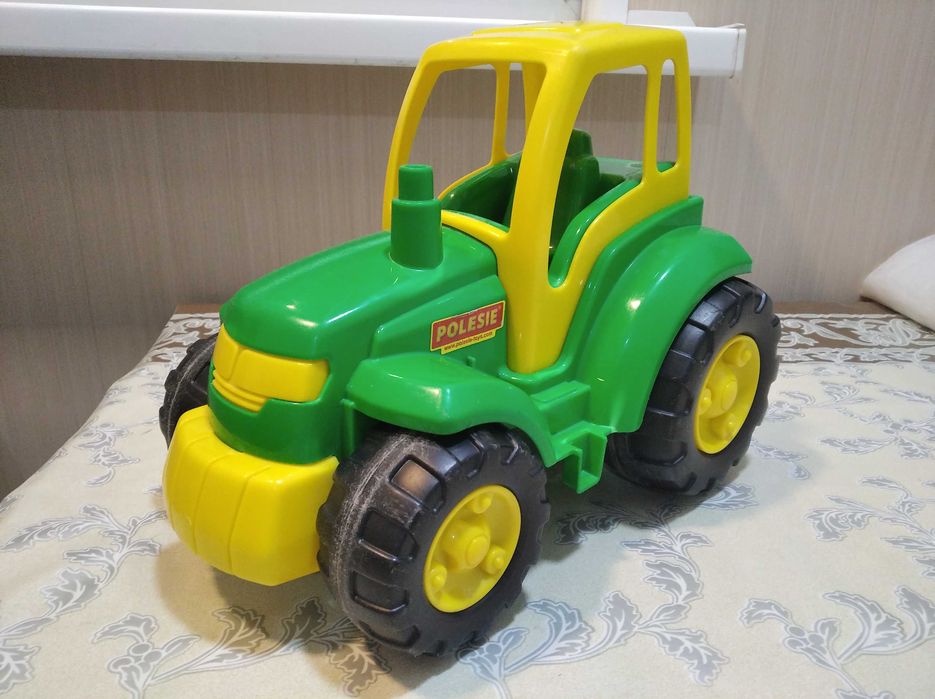 Детская игрушка, трактор и прицеп. Детские игрушки.