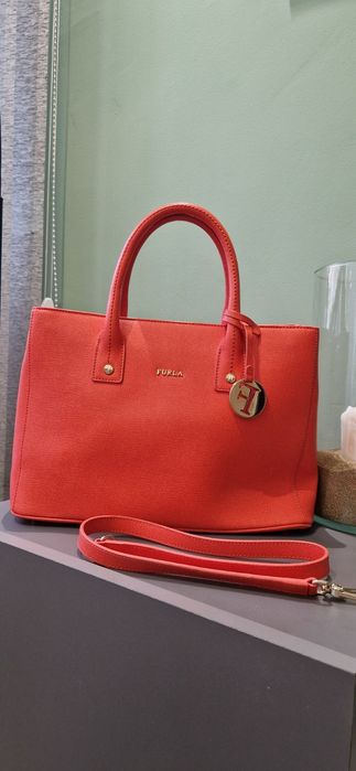 Чанта FURLA Linda S Tote, Ruby
Носена е няколко пъти,но е малко по-голяма от колкото очаквах.
 Размери:31×22.5-23×13-14 cm
Цената е 60 €