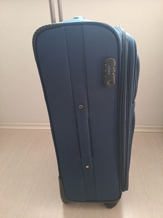 Голям текстилен куфар с вътрешен механизъм.