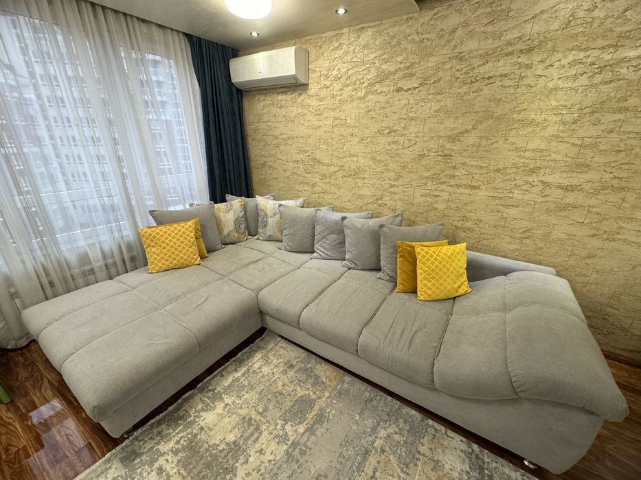 Сив ъглов диван с декоративни възглавници