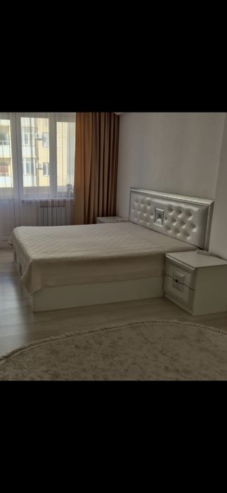 Двухспальная кровать с двумя тумбами.