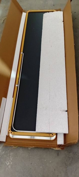 Зеркало в полный рост в тонкой золотистой раме.