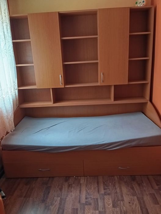 Pat de o persoană cu biblioteca