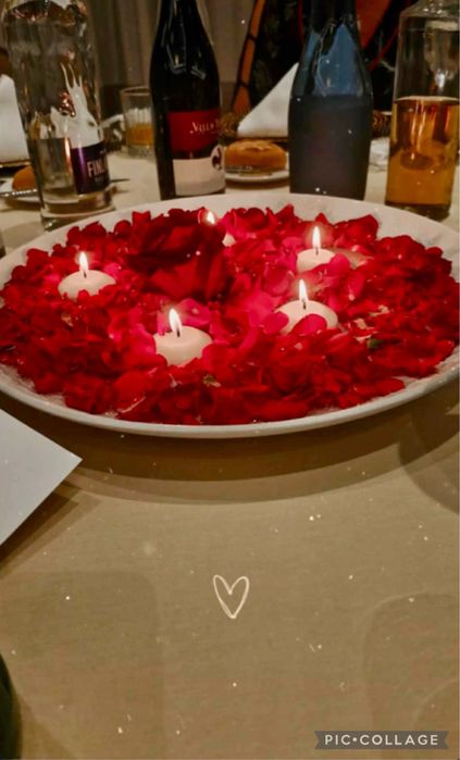 Бяла метална арка с червени рози и друга сватбена украса