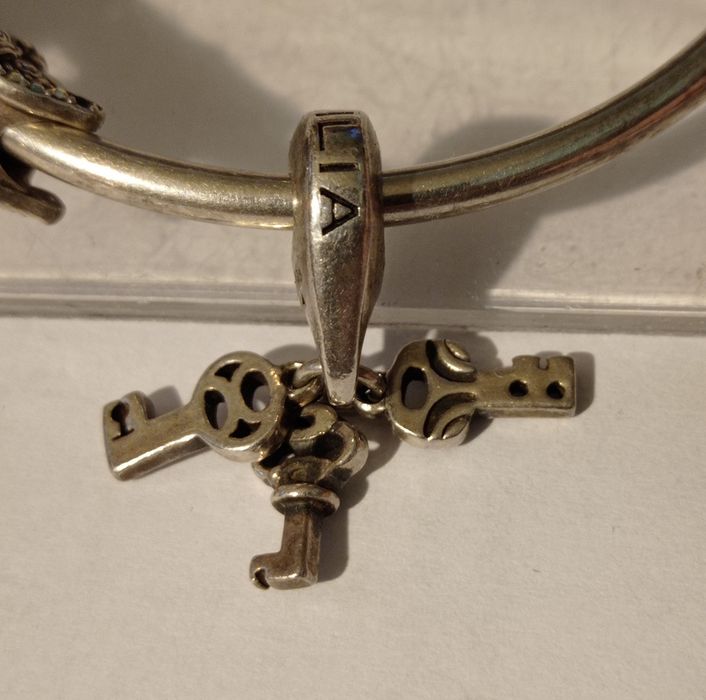 Vând/Schimb brățară Pandora-4 charmuri,la un charm lipsesc 3 pietre.