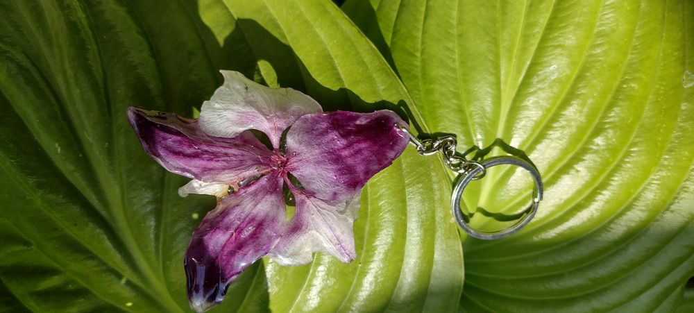 Ключодържател или аксесоар за чанта с естествен цвят на орхидея.