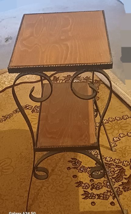 Това е помощна маса в индустриален стил с две нива и метална рамка.