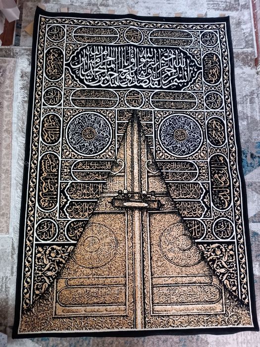 Курон оятлари туширилган деворий гилам.