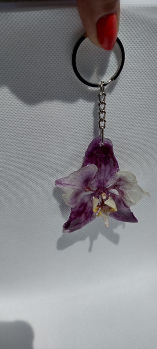 Ключодържател или аксесоар за чанта с естествен цвят на орхидея.