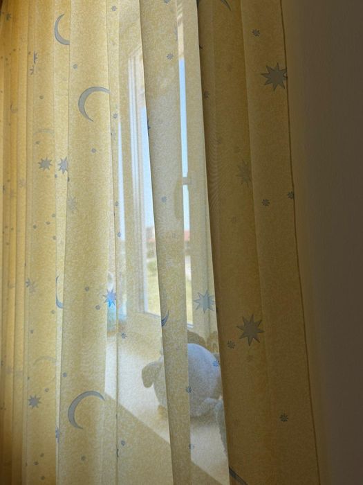 Perdea galbena cu detalii albastre