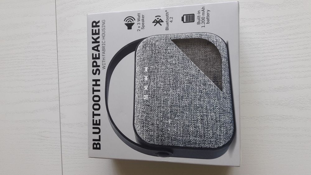 Блутут колонка говорител с текстилна обвивка и гумирана дръжка.