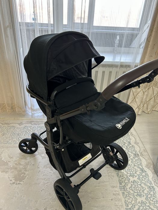 Продаётся современная детская коляска в чёрном цвете.