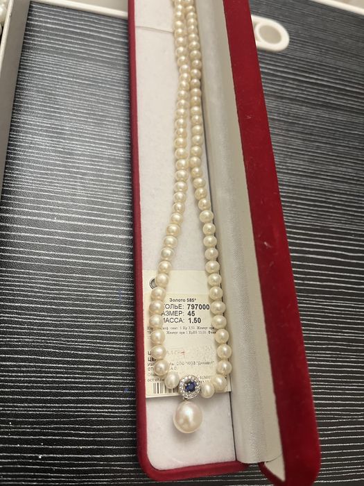 Натуральный жемчуг с золотым кулоном с сапфиром.