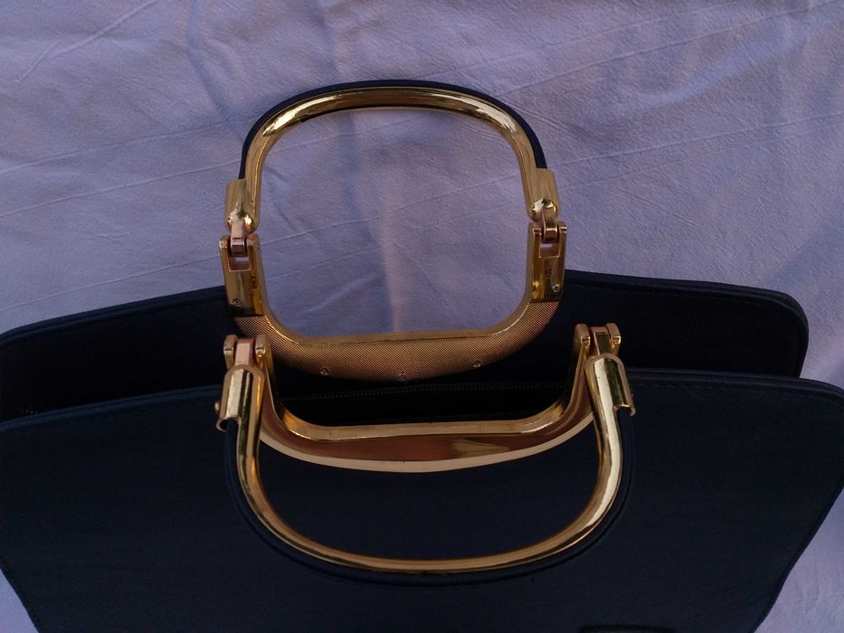 Нова дамска, тъмносиня чанта със златисти елементи.