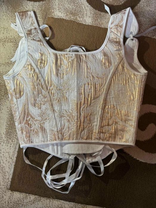 Corset alb cu detalii aurii

elegant şi

versatil