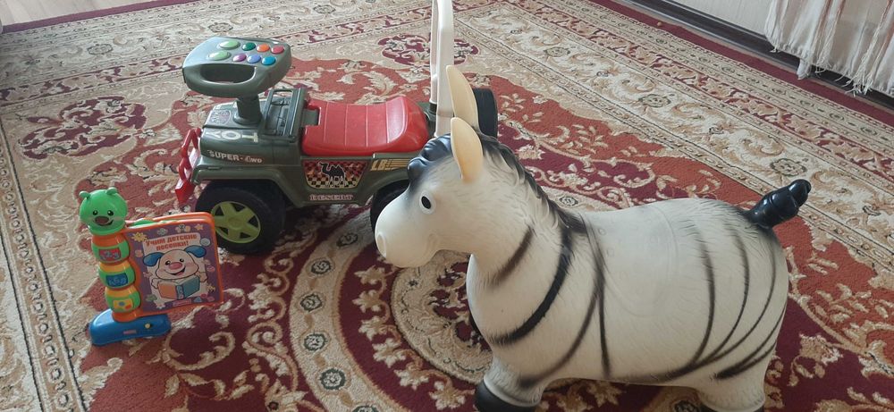 Детские игрушки: машинка-толокар, ослик-прыгун и музыкальная книга