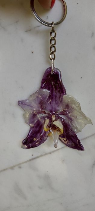 Ключодържател или аксесоар за чанта с естествен цвят на орхидея.
