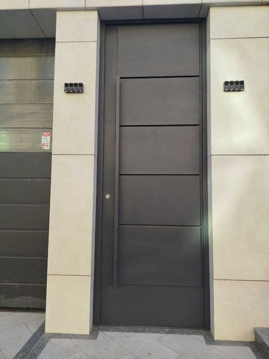 Входные двери в едином стиле с секционными воротами.