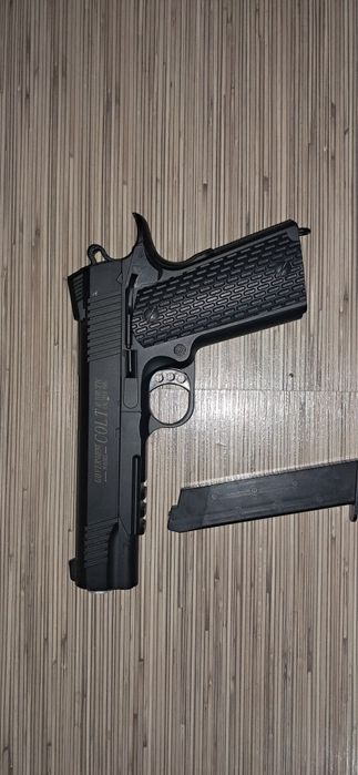Pistol Colt 1911 airsoft, este metalic și pe arc