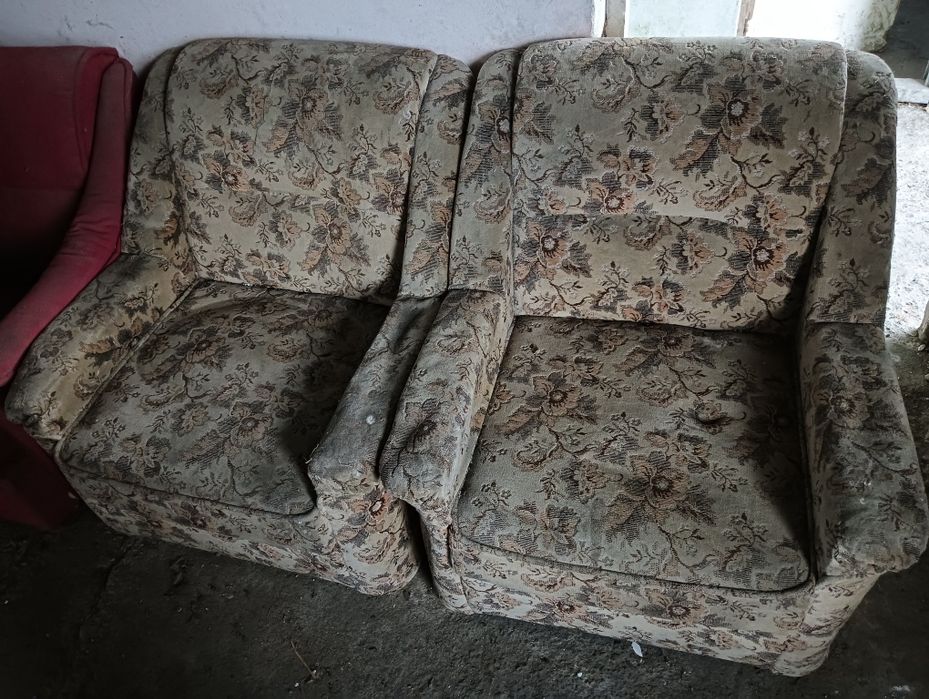 Două fotolii tapițate cu un model floral vintage, în stare de utilizare. Acestea pot fi o opțiune interesantă pentru a adăuga un accent retro