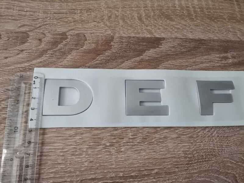сребрист надпис Land Rover Defender