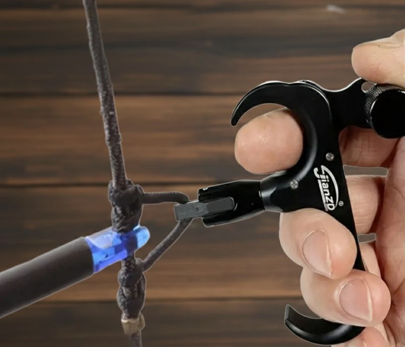 Declansator "thumb release" pentru arc compound