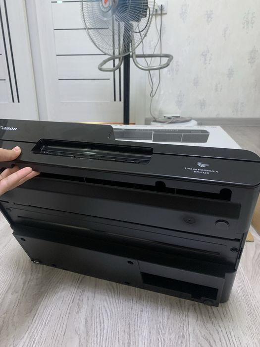 Это сканер документов Canon imageFORMULA DR-F120 черного цвета.