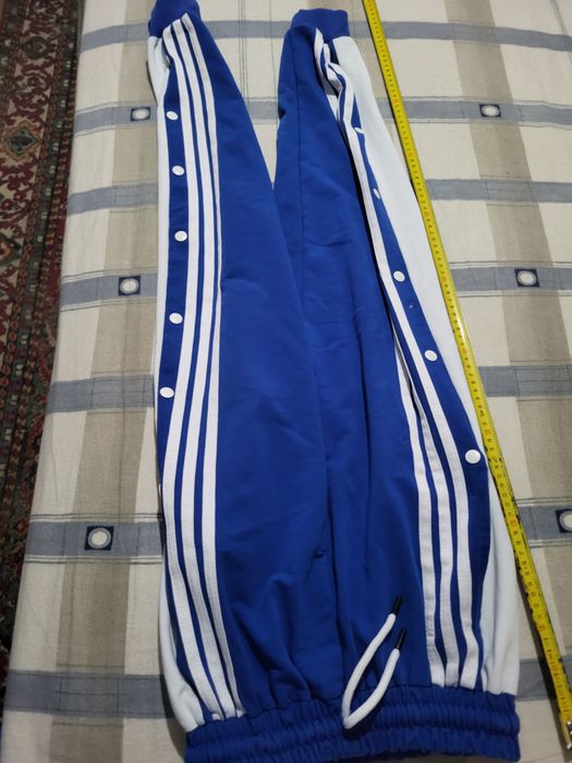 Pantaloni bărbătești de trening culoarea albastru cu dungi albe si capse albe.