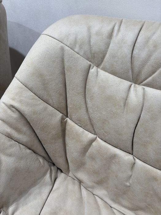 Кресло, обитое тканью, с ножками из натурального дерева.