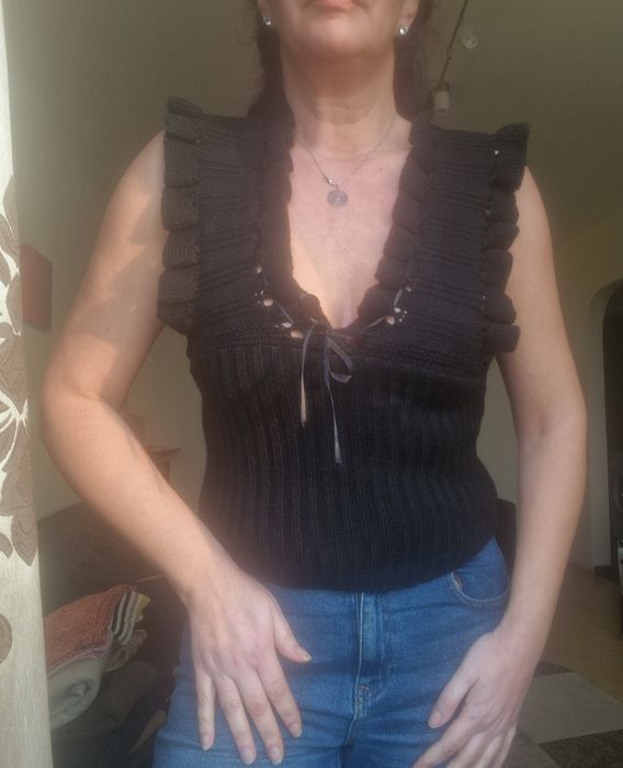 Top model tricotat negru, cu volane la umeri și gat