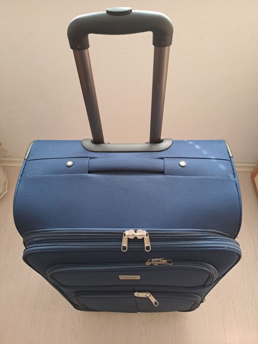 Голям текстилен куфар с вътрешен механизъм.