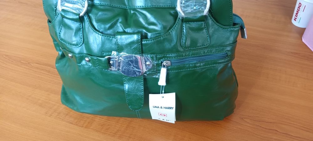 Дамска чанта от зелена еко кожа с къса и с дълга дръжка и ефектна катарама.Разпределението вътре е от две отделения и преграда с цип в средата