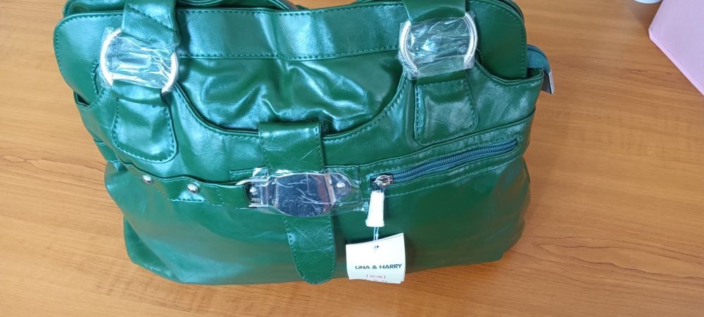 Дамска чанта от зелена еко кожа с къса и с дълга дръжка и ефектна катарама.Разпределението вътре е от две отделения и преграда с цип в средата