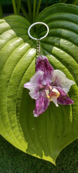 Ключодържател или аксесоар за чанта с естествен цвят на орхидея.